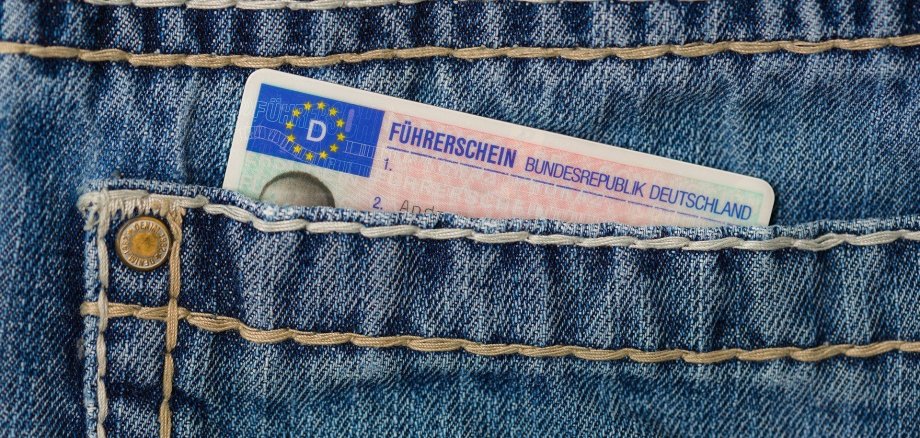 Die Gesäßtasche einer Jeans. Ein Führerschein schaut oben heraus.